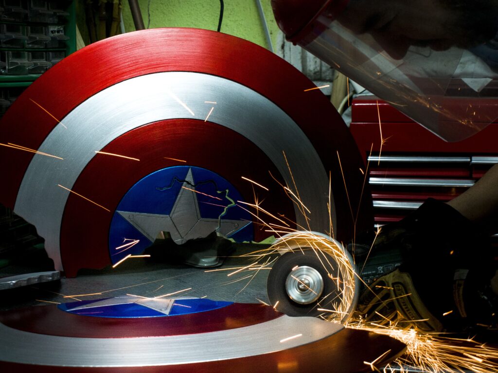 Pulido artesanal del escudo del Capitán América con chispas metálicas.